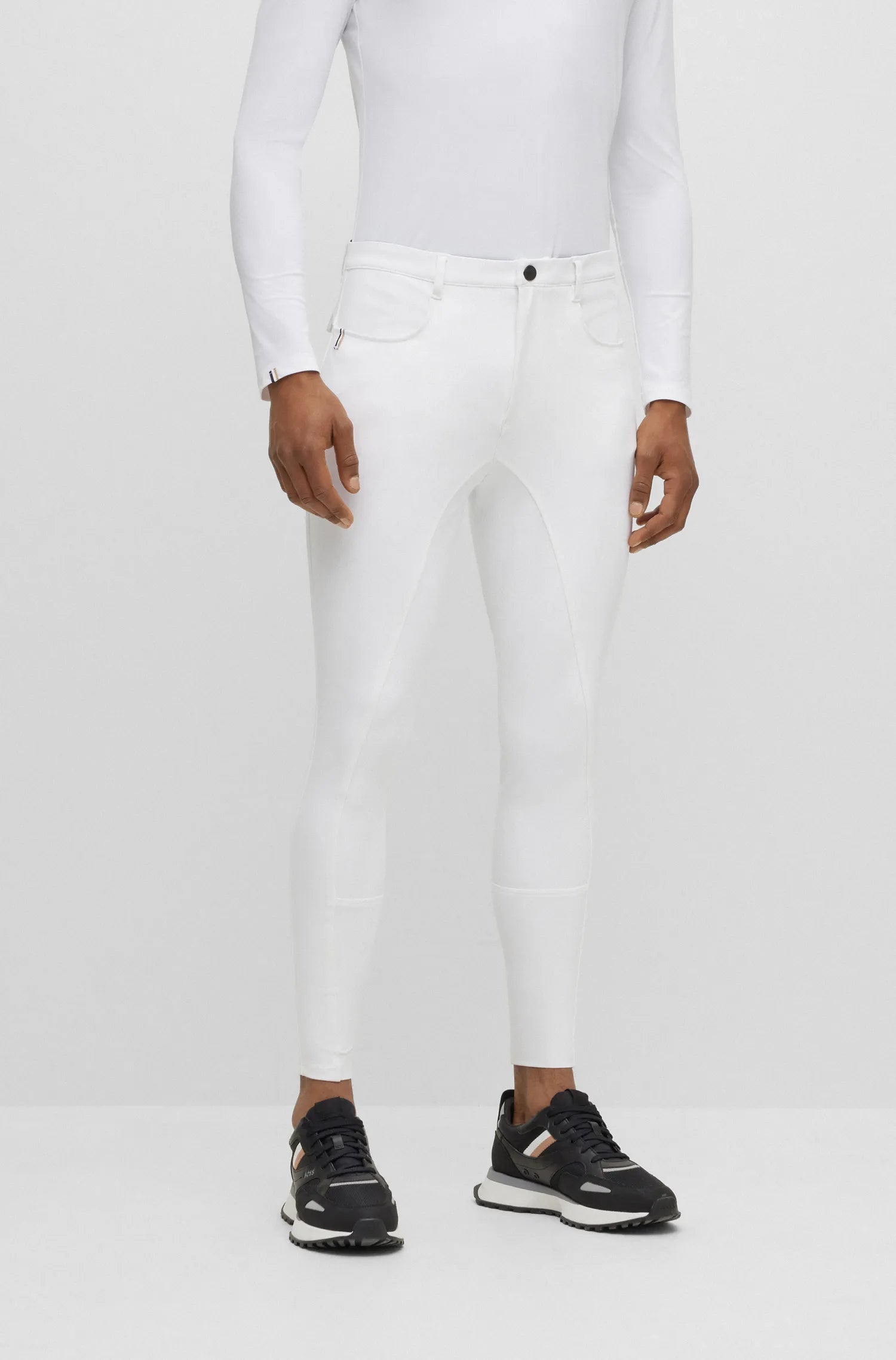 White | Person wearing white pants and black shoes on a white background