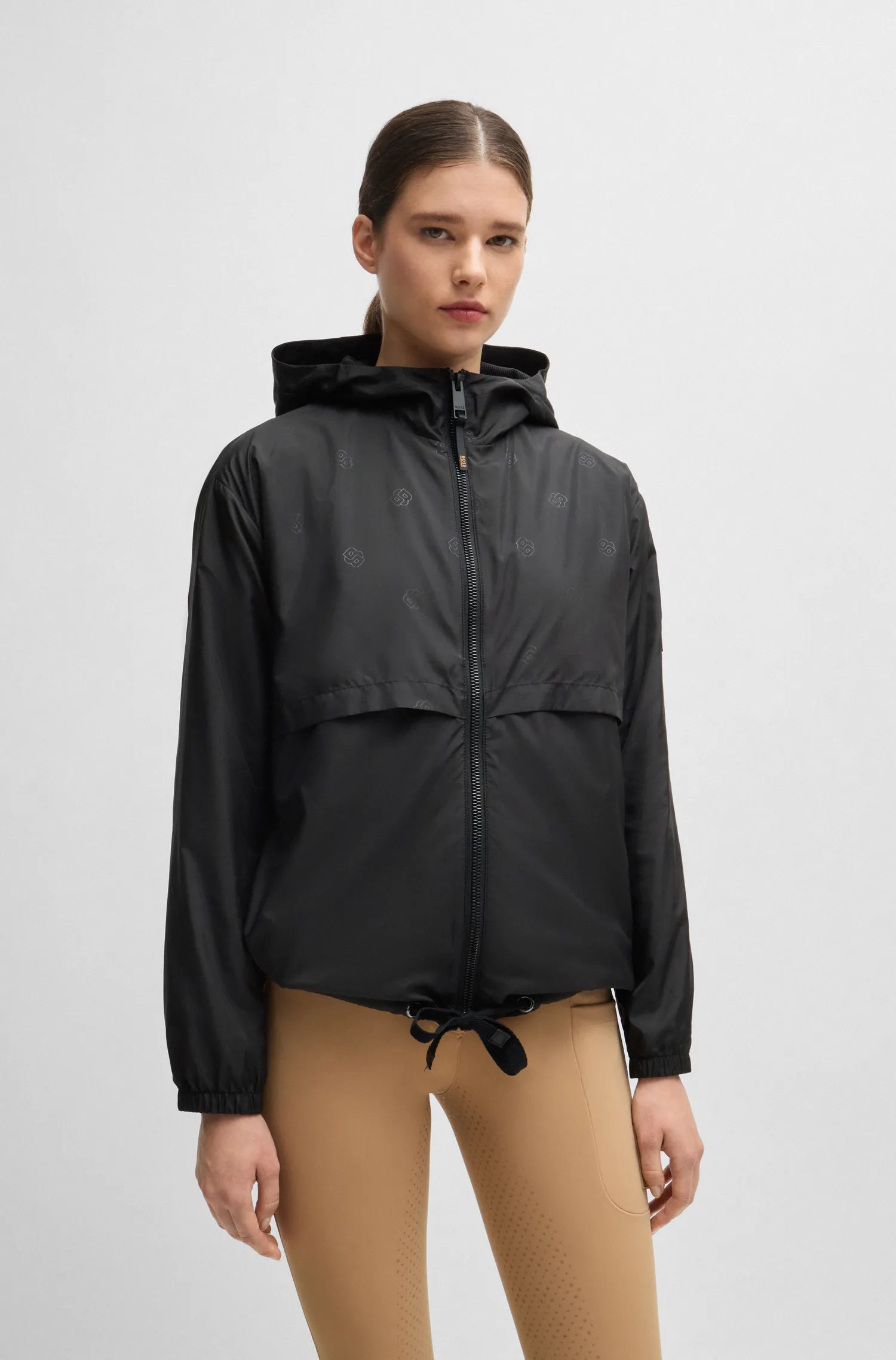 Black | Person wearing a black hooded jacket on a light gray background