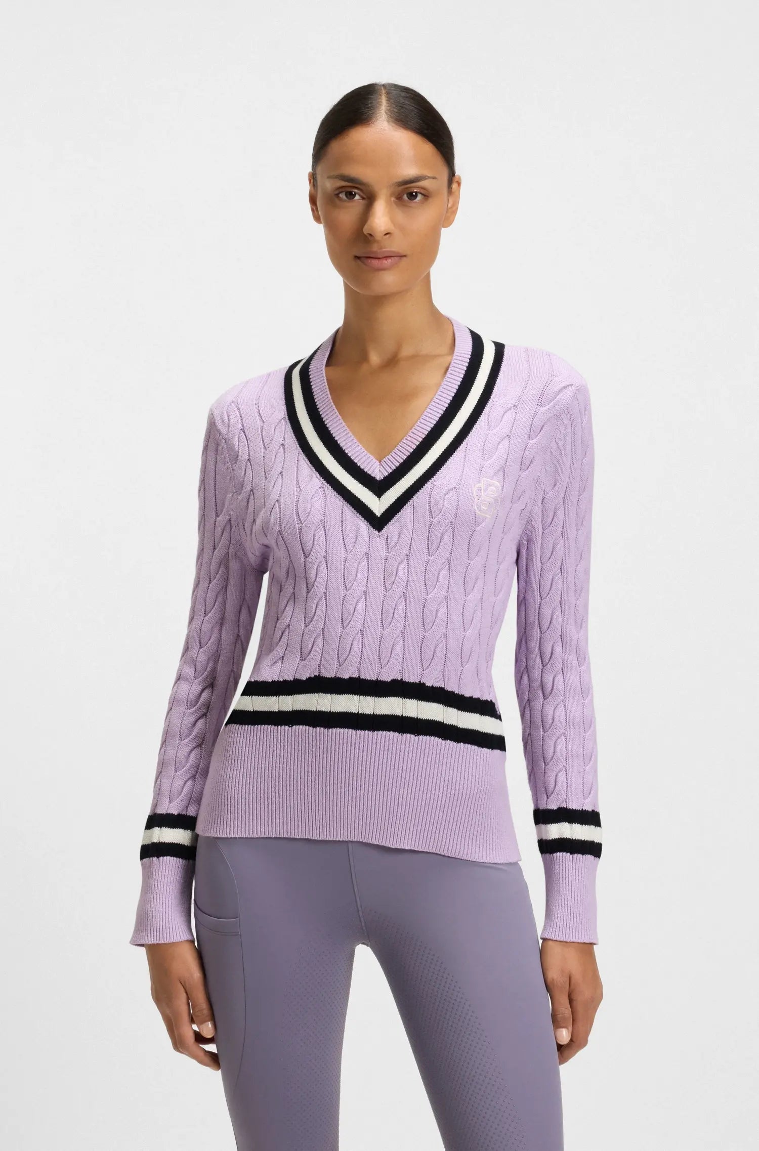 Orchid | Woman wearing a purple sweater with black and white stripes on a light gray background