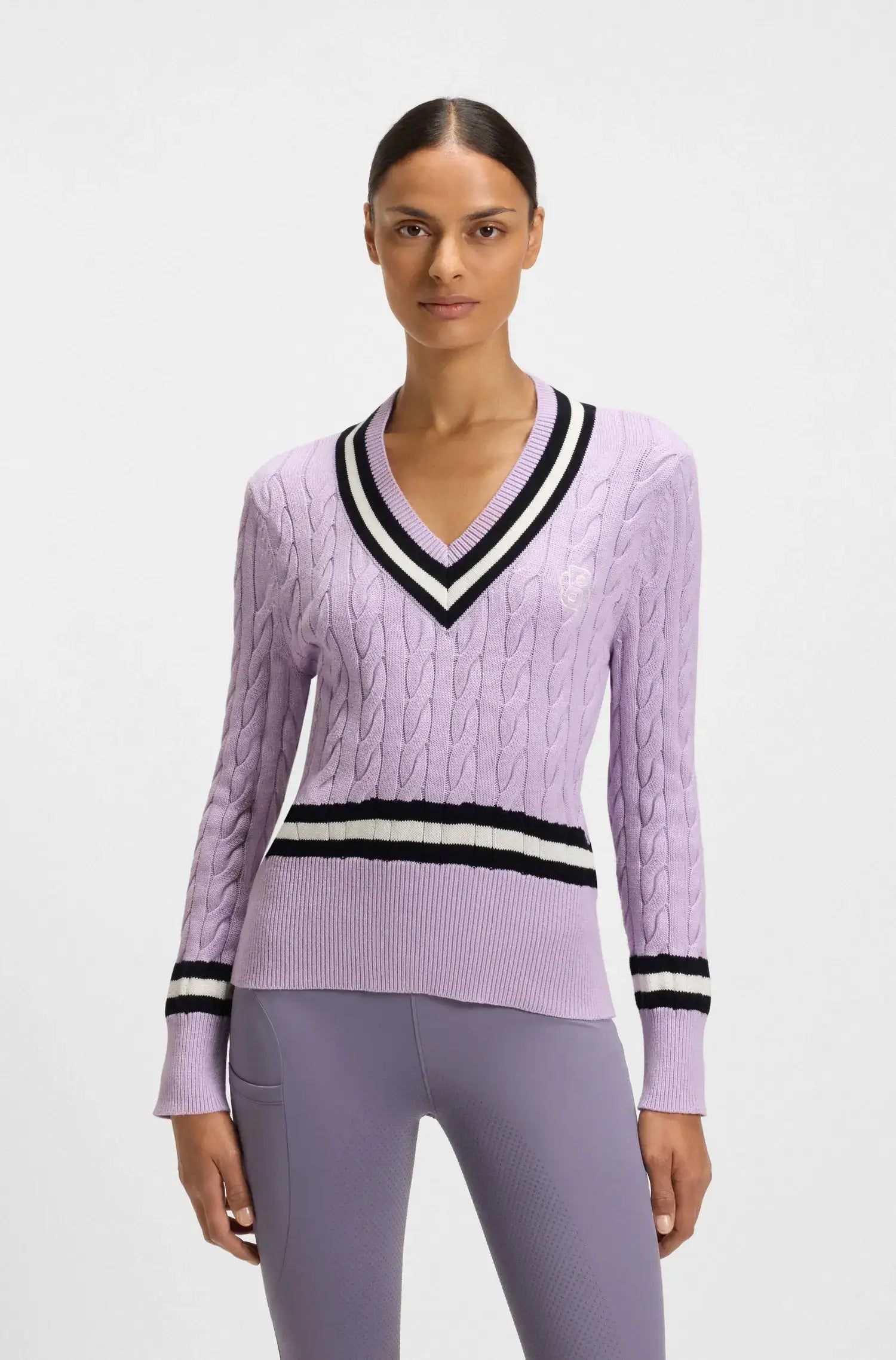Orchid | Woman wearing a purple sweater with black and white stripes on a light gray background